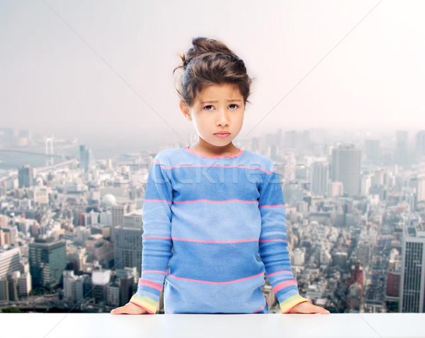 sad little girl over city background Stock photo © dolgachov