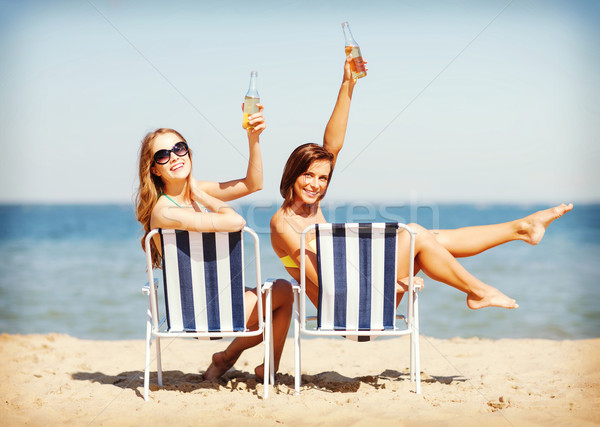 girls sunbathing on the beach chairs Stock photo © dolgachov