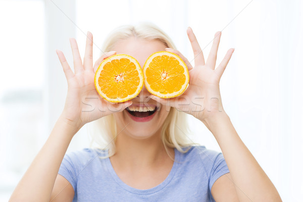 happy woman having fun covering eyes with orange Stock photo © dolgachov