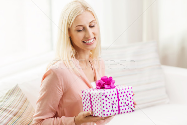 smiling woman with gift box at home Stock photo © dolgachov