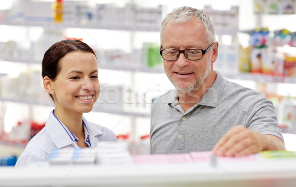 pharmacist showing drug to senior man at pharmacy Stock photo © dolgachov