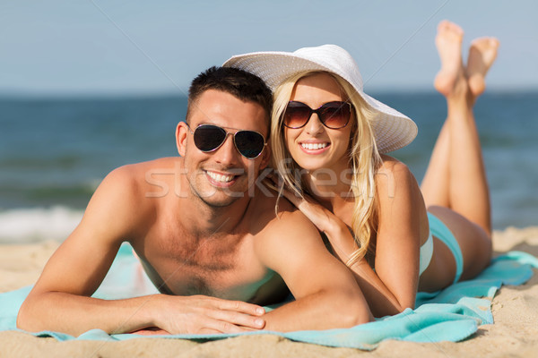 happy couple in swimwear lying on summer beach Stock photo © dolgachov