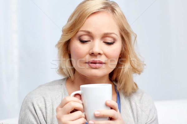 woman with cup of tea or coffee at home Stock photo © dolgachov