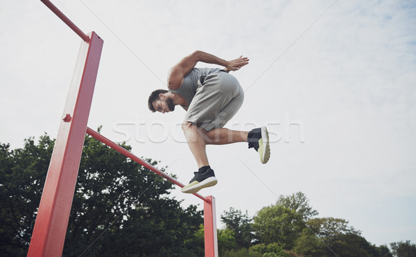 Tânăr jumping orizontala bar în aer liber fitness Imagine de stoc © dolgachov