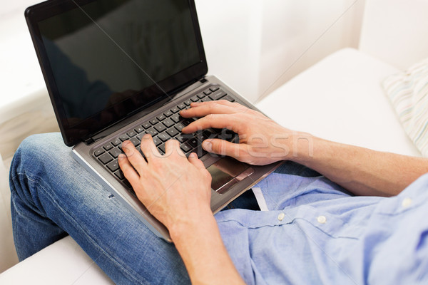 close up of man typing on laptop computer at home Stock photo © dolgachov