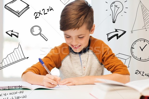 Zâmbitor student băiat scris blocnotes acasă Imagine de stoc © dolgachov