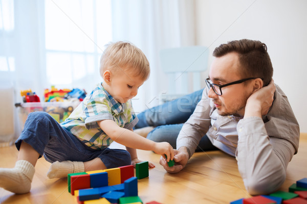 father and son playing with toy blocks at home Stock photo © dolgachov