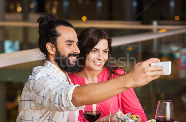 couple taking selfie by smartphone at restaurant Stock photo © dolgachov