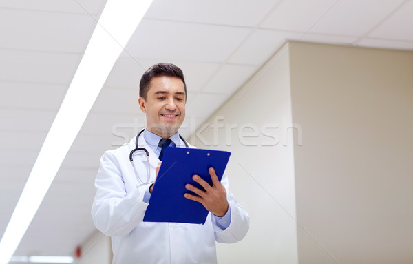Uśmiechnięty lekarza schowek szpitala korytarz kliniki Zdjęcia stock © dolgachov