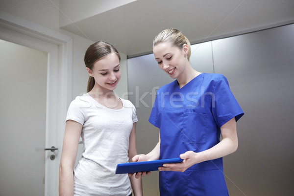smiling nurse with tablet pc and girl at hospital Stock photo © dolgachov