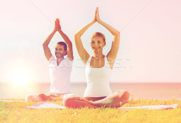 Glimlachend paar yoga buitenshuis fitness Stockfoto © dolgachov