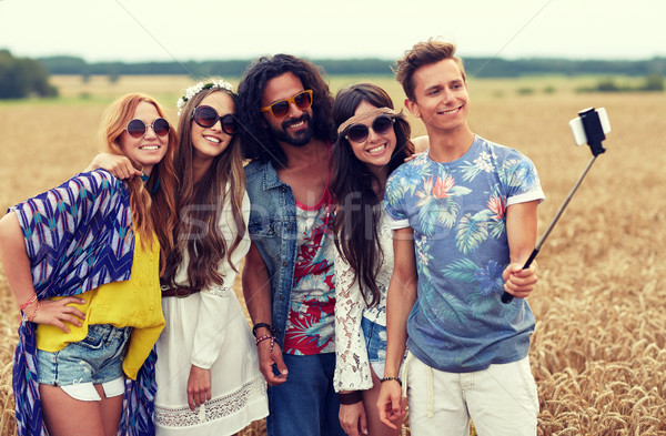 hippie friends with smartphone on selfie stick Stock photo © dolgachov