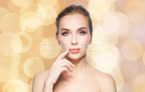 beautiful woman showing her lips over lights Stock photo © dolgachov