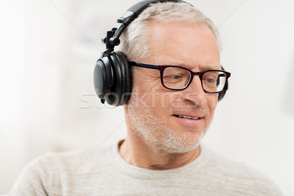 happy man in headphones listening to music at home Stock photo © dolgachov