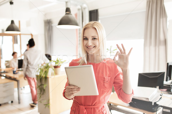 woman with tablet pc showing ok sign at office Stock photo © dolgachov