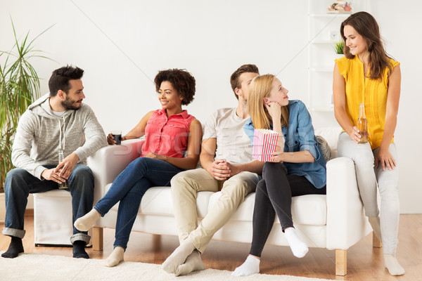 Stock photo: happy friends with popcorn and beer at home