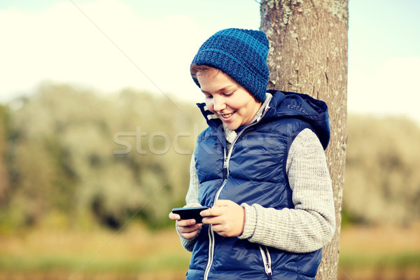 happy boy playing game on smartphone outdoors Stock photo © dolgachov