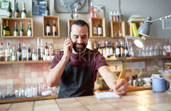 happy man or waiter at bar calling on smartphone Stock photo © dolgachov