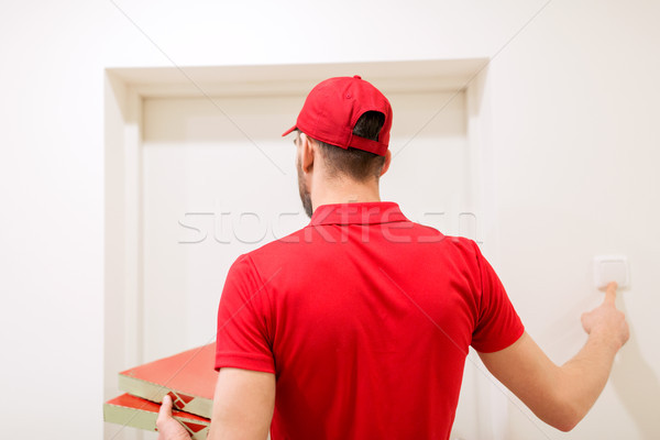 delivery man with pizza boxes ringing doorbell Stock photo © dolgachov
