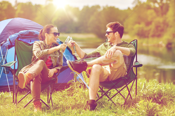 Stock photo: happy couple clinking drinks at campsite tent