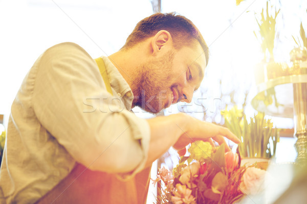 Stock photo: smiling florist man making bunch at flower shop