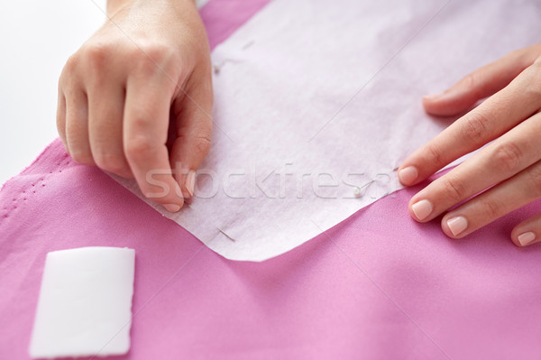 Stock photo: woman with pins stitching paper pattern to fabric