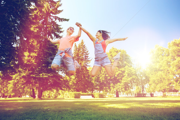 happy teenage couple jumping at summer park Stock photo © dolgachov