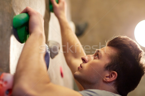 Stock photo: young man exercising at indoor climbing gym wall
