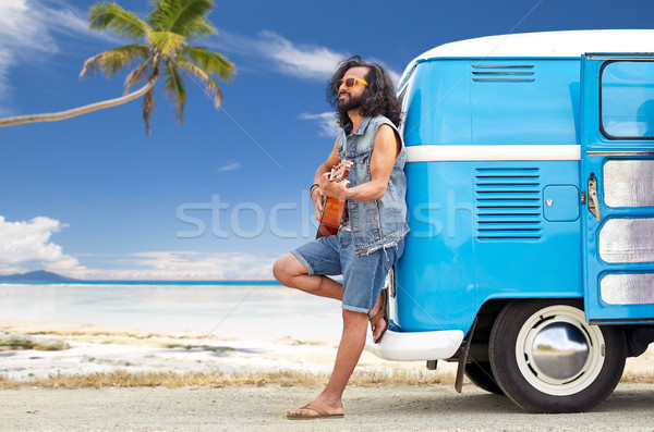 hippie man playing guitar at minivan car on beach Stock photo © dolgachov