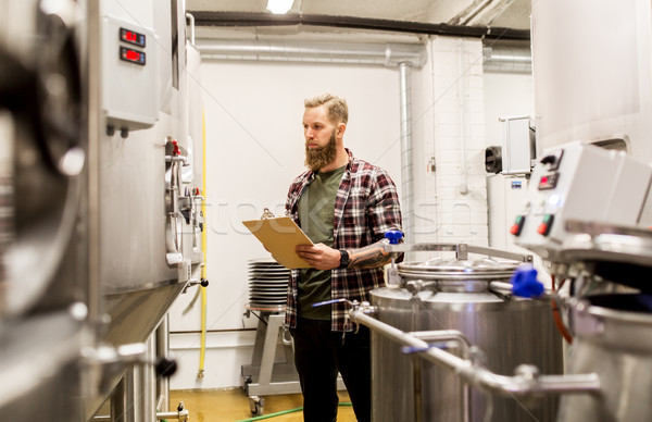 Om clipboard fabrica de bere bere plantă oameni de afaceri Imagine de stoc © dolgachov