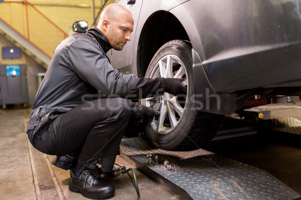 auto mechanic changing car tire at workshop Stock photo © dolgachov