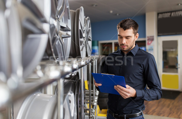 auto business owner and wheel rims at car service Stock photo © dolgachov