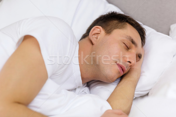 Knappe man slapen bed hotel reizen geluk Stockfoto © dolgachov