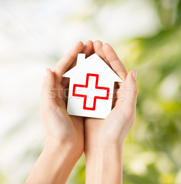 hands holding paper house with red cross Stock photo © dolgachov