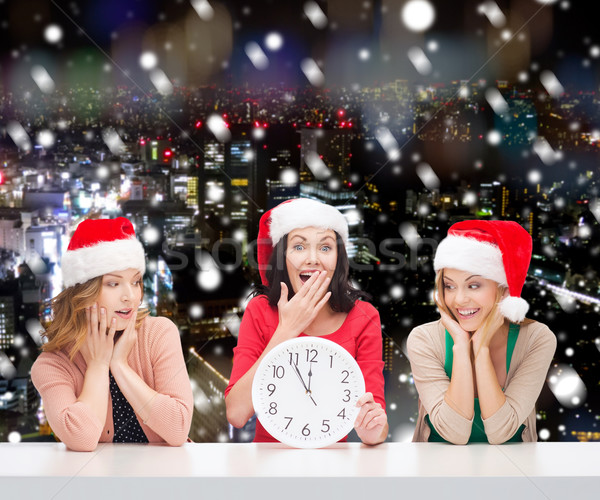 smiling women in santa helper hats with clock Stock photo © dolgachov