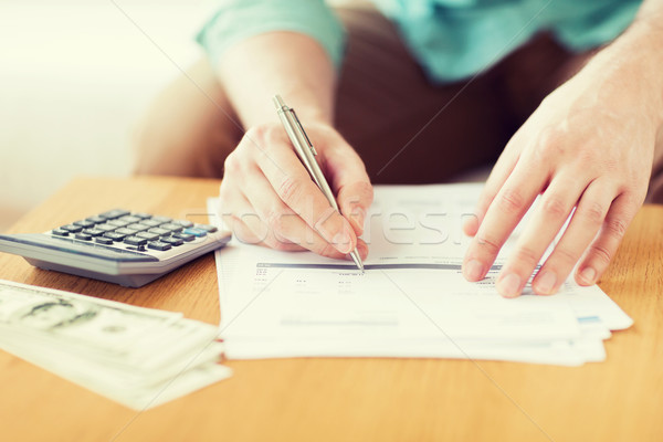 close up of man counting money and making notes Stock photo © dolgachov