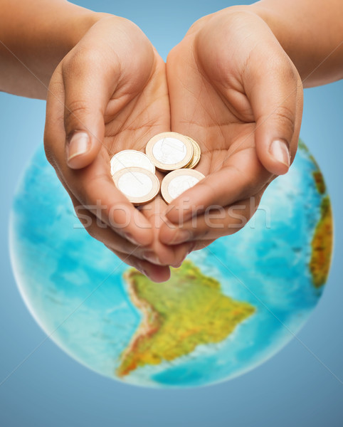 cupped hands holding euro coins over earth globe Stock photo © dolgachov