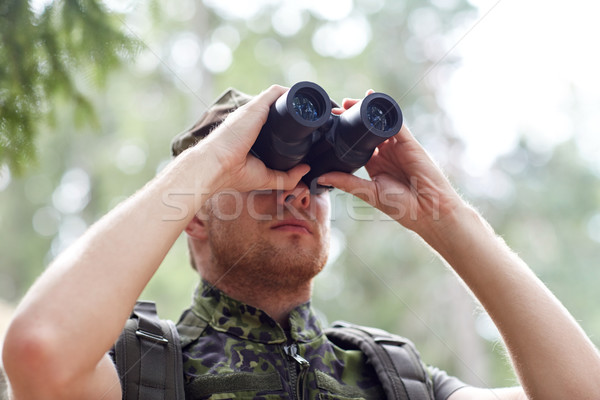Stock photo: young soldier or hunter with binocular in forest