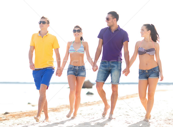 group of happy friends walking along beach Stock photo © dolgachov