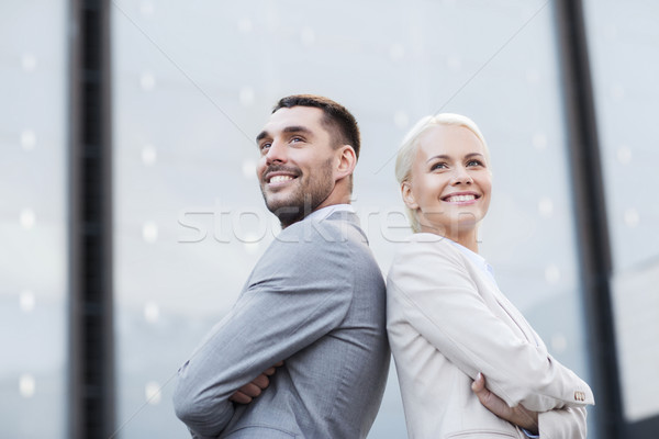 Stock photo: smiling businessmen standing over office building