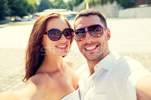 smiling couple wearing sunglasses making selfie Stock photo © dolgachov