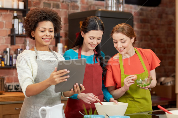 happy women with tablet pc cooking in kitchen Stock photo © dolgachov