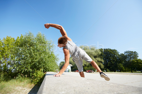 sporty young man jumping in summer park Stock photo © dolgachov