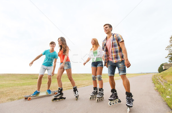 happy teenagers with rollerblades and longboards Stock photo © dolgachov