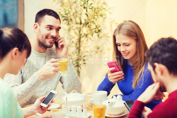 group of friends with smartphones meeting at cafe Stock photo © dolgachov