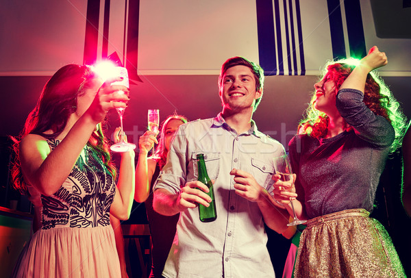 smiling friends with wine glasses and beer in club Stock photo © dolgachov