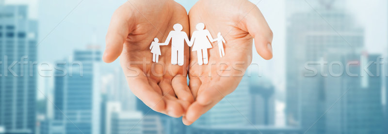 man hands holding paper cutout of family Stock photo © dolgachov