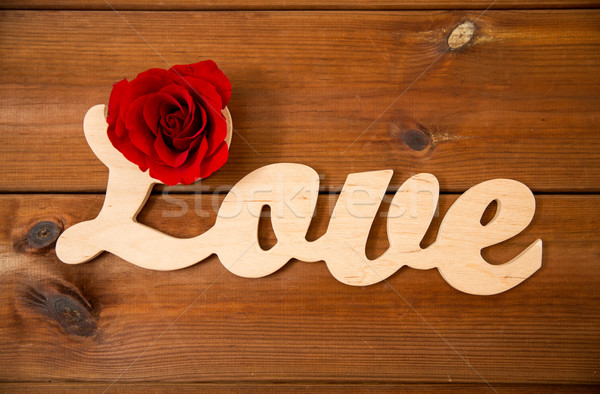 close up of word love cutout with red rose on wood Stock photo © dolgachov