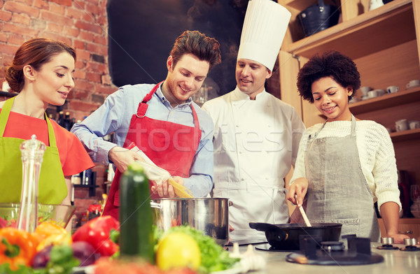 happy friends and chef cook cooking in kitchen Stock photo © dolgachov