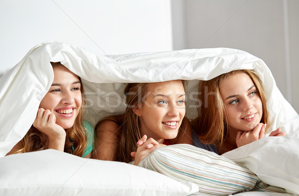 happy young women in bed at home pajama party Stock photo © dolgachov